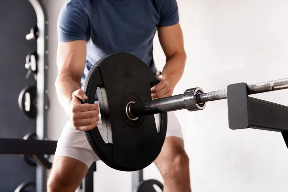 Man preparing a 20kg weight for lifting.