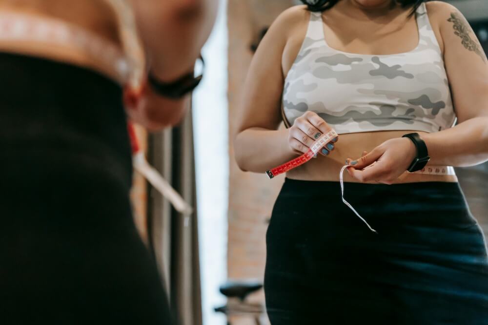 Woman measuring herself with tape.