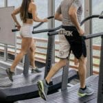 Man and woman incline walking on a treadmill